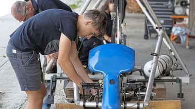 Jugendliche und Erwachsene montieren Steuerseile an einem Flugzeugprojekt im Rahmen eines OUV-Jugendprojekts.