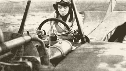 Historische Fotografie von Melli Beese im Cockpit eines Rumpler-Taube-Flugzeugs von 1911. Die Aufnahme zeigt die erste deutsche Frau mit Flugzeugführerschein am Steuer des Doppeldeckers.