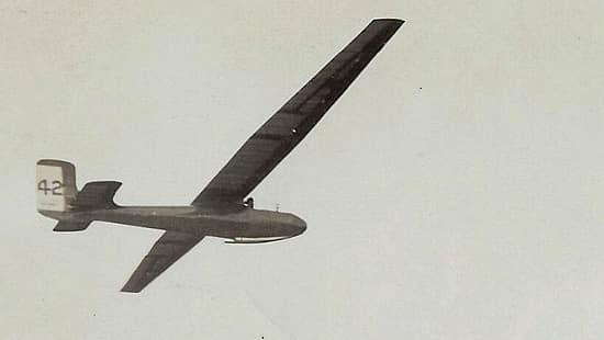 Historische Schwarzweißaufnahme eines Rekordseglers im Flug, vermutlich aus dem Archiv des Deutschen Segelflugmuseums. Das Segelflugzeug ist von unten zu sehen, mit markanter langer Tragfläche und der Nummer 42 am Seitenleitwerk.